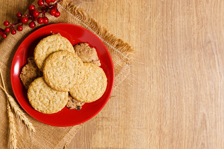 Christmas cookies decorated on red color plate for winter holiday celebrations on wooden table. top view.の写真素材