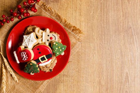 Christmas cookies decorated with frosting and icing for winter holiday celebrations on wooden table.の写真素材