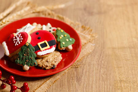 Christmas cookies decorated with frosting and icing for winter holiday celebrations on wooden table.の写真素材