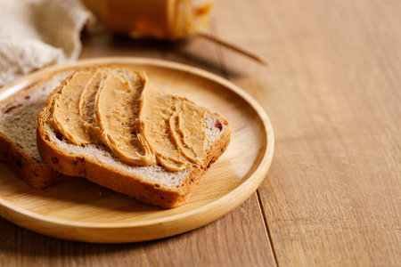 chocolate hazelnut spread on a single slice of toast on wooden table.の写真素材