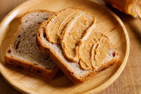 chocolate hazelnut spread on a single slice of toast on wooden table.の写真素材