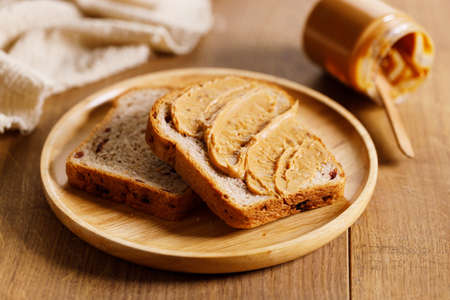 chocolate hazelnut spread on a single slice of toast on wooden table.の写真素材