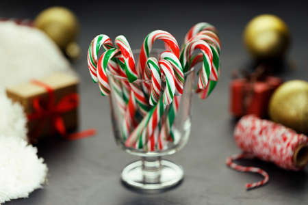 candy canes with red, green and white color in a glass on dark background.の写真素材