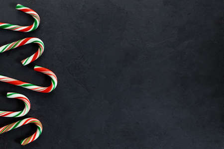 candy canes with red, green and white color on dark background, top view.の写真素材