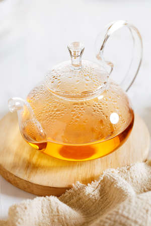 Herbal teapot with steam on wooden plate, closeupの写真素材