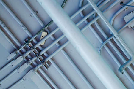 Pipes and conduits in a white rustic ceiling background. Look up view. construction background concept.の写真素材