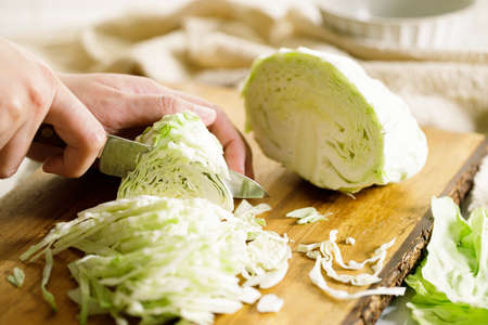 Closeup of women hand chopping fresh vegetable on cutting board. preparing a healthy meal concept.の写真素材