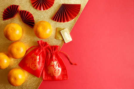 Chinese new year festival decoration with red bags, oranges and red Chinese folded fans on red background. Celebrate Happy Chinese new year background concept. top view with copy space.の写真素材