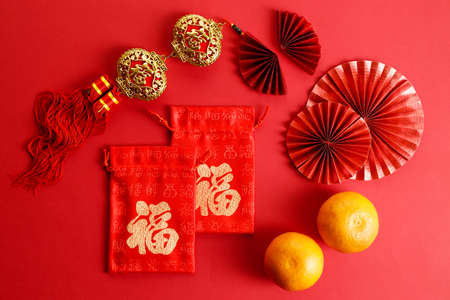 Chinese new year festival decoration with red envelopes and red Chinese folded fans on red background. Celebrate Happy Chinese new year background concept. top view.の写真素材