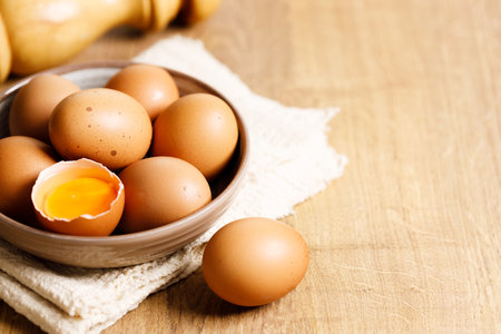 Closeup raw eggs on kitchen wooden table. Fresh and nutritious brown eggs.の写真素材