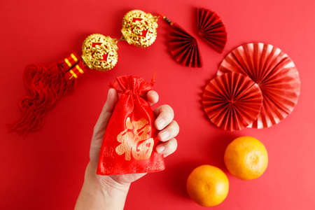 Chinese new year festival decoration with red envelopes and red Chinese folded fans on red background. Celebrate Happy Chinese new year background concept. top view.の写真素材