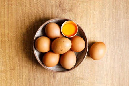 Top view of raw eggs on kitchen wooden table. Fresh and nutritious brown eggs.の写真素材