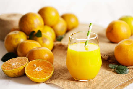 Glass of orange juice with sliced orange on wooden table background.の写真素材
