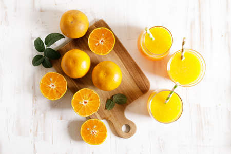 Glass of orange juice with sliced orange on wooden table background. top view.の写真素材