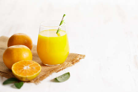 Glass of orange juice with sliced orange on wooden table background. copy space.の写真素材