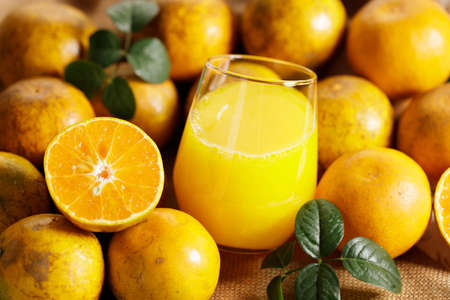 Glass of orange juice with sliced orange on wooden table background.の写真素材