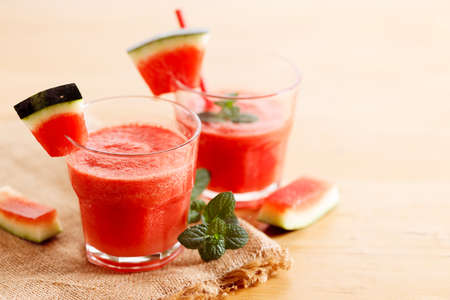 Fresh watermelon juice with mint in a glass on wooden table. Closeup.の写真素材