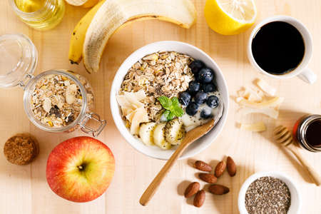Healthy breakfast with yogurt, granola and fresh blueberries in a bowl on wooden table. Healthy eating and dieting concept.の写真素材