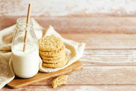 Oatmeal cookies with bottle of milk on wooden table background. Closeup. Healthy snack with milk concept.の写真素材