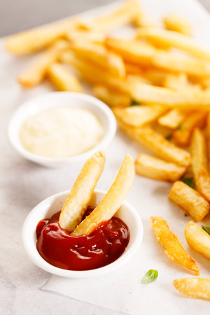 Potato fries with mayo and ketchup on wooden table.の写真素材