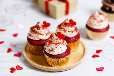 Small cupcakes with red hearts on wooden background. Valentineâs day and sweet pastries concept.の写真素材