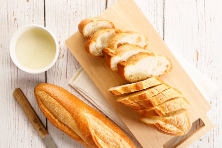 Baguette slices on wooden plank. Top view.の写真素材