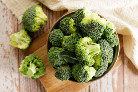 Fresh green broccoli florets in a bowl on wooden background.の写真素材