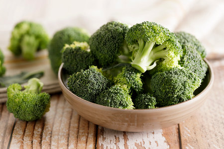 Fresh green broccoli florets in a bowl on wooden background.の写真素材