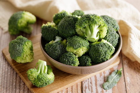Fresh green broccoli florets in a bowl on wooden background.の写真素材