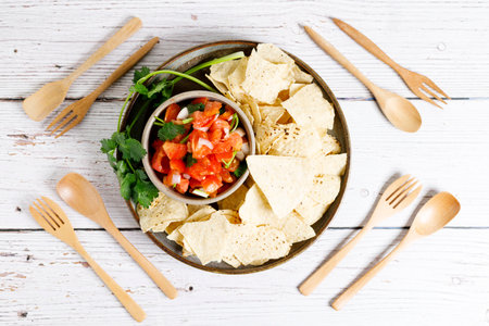 Tomato salsa with tortilla chips on white wooden table.の写真素材