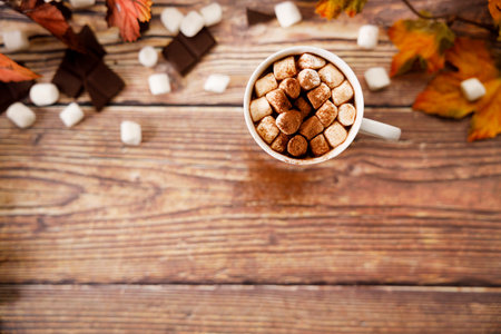 Hot chocolate with marshmallows in a white ceramic cup on wooden table.の写真素材