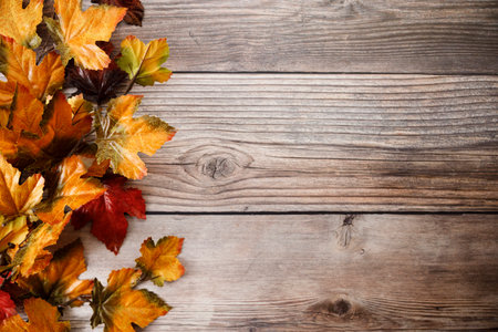 Autumn red and yellow leaves on wooden table background. Top view with copy space.