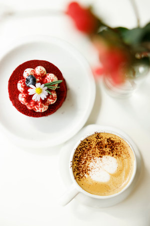 Red velvet cake decorated with flower on white table with hot milk art coffee. Top view.の写真素材