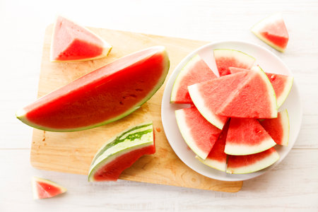 Fresh sliced watermelon on white wooden table background. Summer sweet eating concept.の写真素材