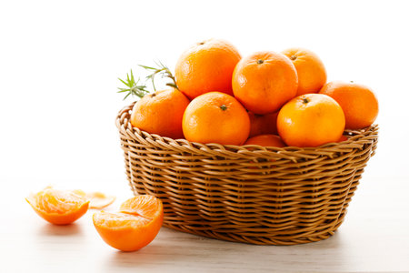 Fresh mandarin oranges fruit or tangerines in wooden basket. Closeup.の写真素材