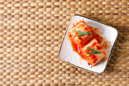 Kimchi cabbage. Korean traditional cabbage kimchi, fermented cabbages, in a white plate. Closeup.の写真素材