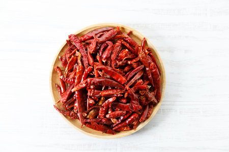 Dried red hot chili peppers on wooden tray. Closeup.の写真素材
