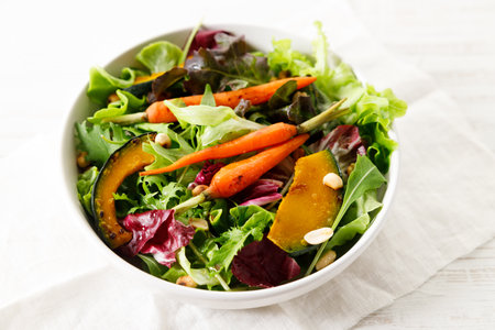Healthy vegetable salad of grilled carrot, roasted pumpkin and green leaf. Diet menu.の写真素材