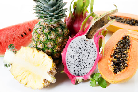 Creative layout made of fruits. Watermelon, pineapple, dragon fruit and papaya on white background. Top view. Summer food concept.の写真素材