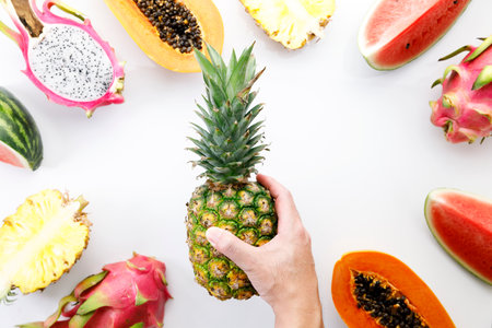 Creative layout made of fruits. Watermelon, pineapple, dragon fruit and papaya on white background....