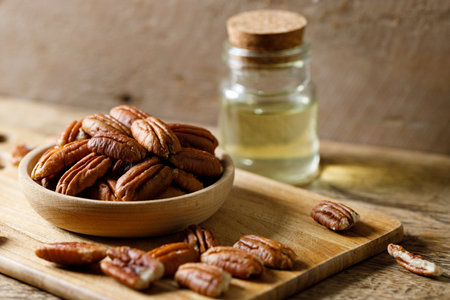 Pecan nuts on rustic wooden table in a wooden bowl. Closeup.の写真素材