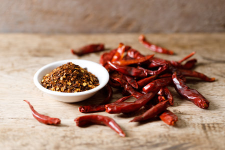 Dried red hot chili peppers and chillies ground on wooden table. Closeup.の写真素材