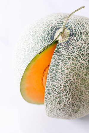 Slices of fresh sweet cantaloupe melon, orange melon, on white marble background.