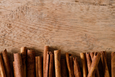 Cinnamon sticks dried tree bark spice on rustic wooden table background. Closeup.