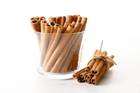 Cinnamon sticks, dried tree bark spice on white wooden table background. Closeup.の写真素材