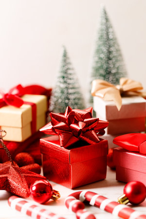 Assorted red and white gift boxes tied with bows on white wooden background. Christmas decorations, balls and stars on wooden background. Christmas New year concept.の写真素材