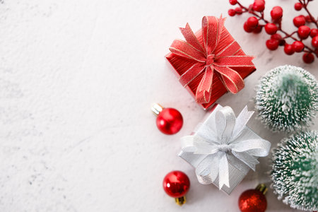 Red and white gift boxes tied with bows on white marble background. Christmas decorations, red balls and Christmas tree on white background. Christmas New year concept. Top view.の写真素材