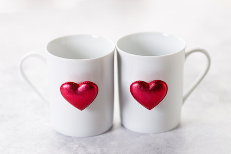 Cups of coffee or tea for two with red heart shaped ornament on white marble background. Valentineâs day and love concept.の写真素材