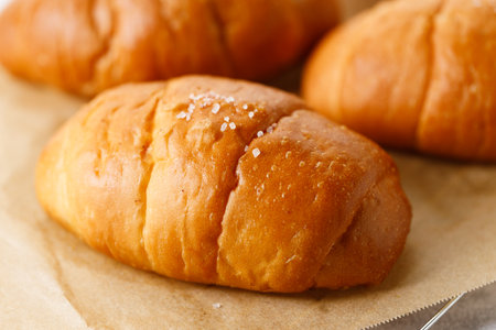Close up plate of Shio Pan, Japanese salted butter rolls on brown baking paper.の写真素材