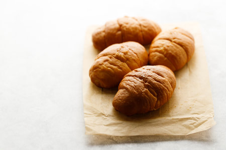 Close up plate of Shio Pan, Japanese salted butter rolls on brown baking paper.の写真素材
